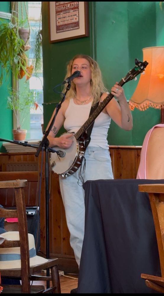 Ella Spencer singing and playing the banjo at the Betsey Trotwood pub