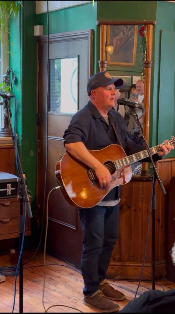 Paul Nowak singing and playing guitar at the Betsey Trotwood pub