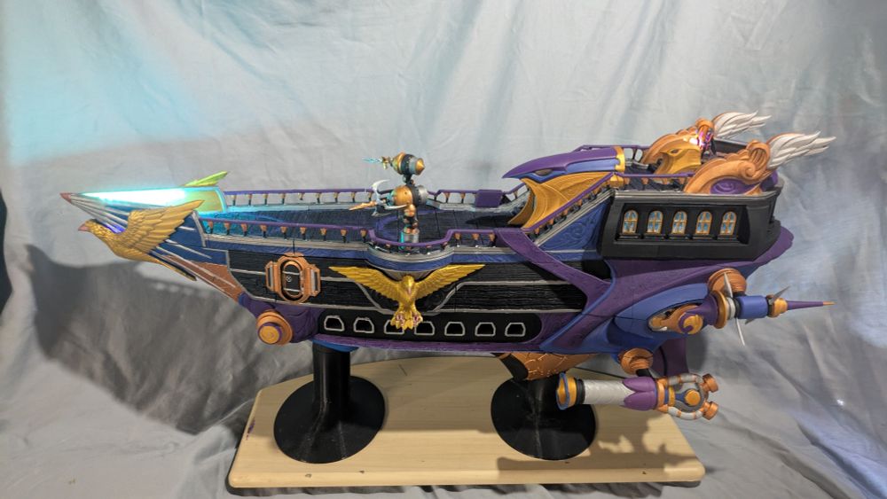 Ttrpg ship painted black, silver, gold, and purple