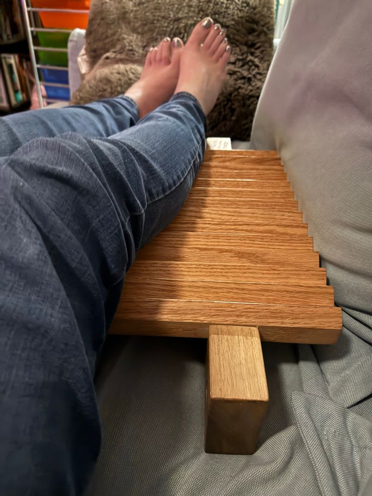 My legs in jeans laying across a Ishidaki board 