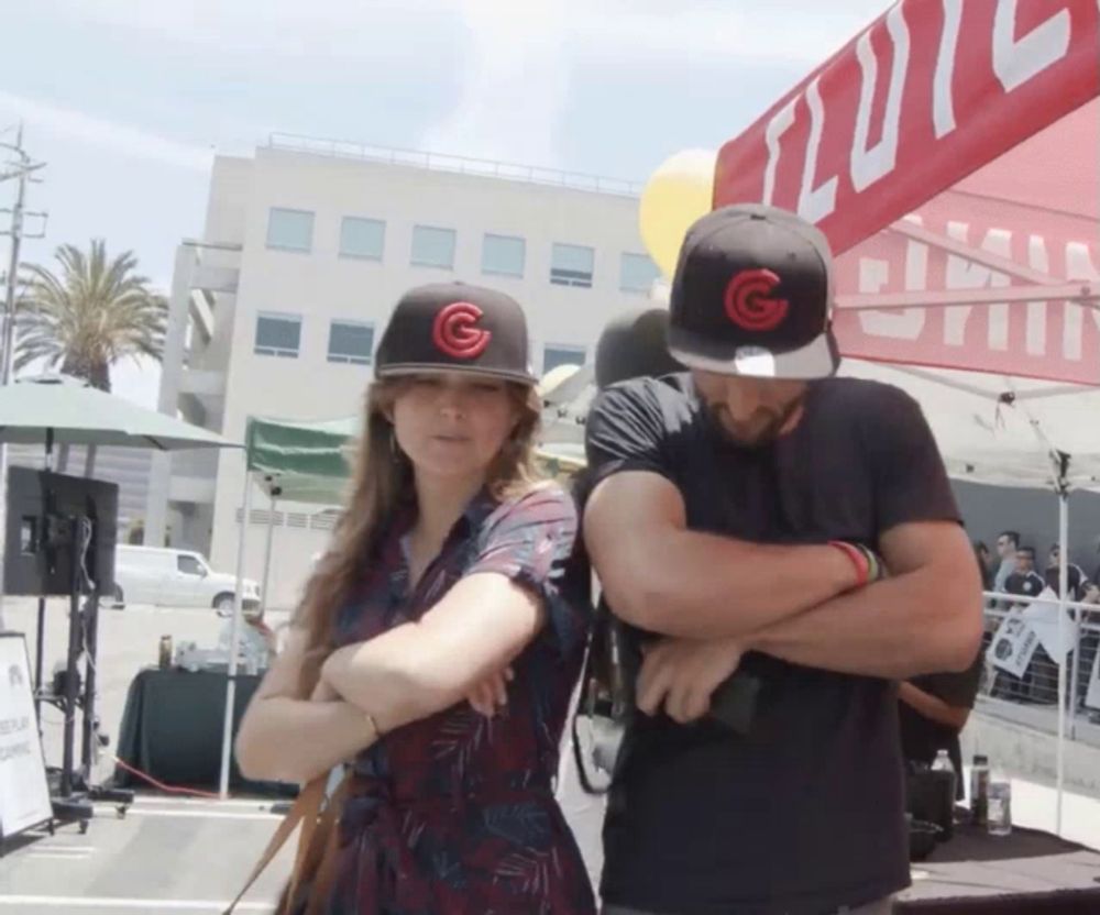 a man and a woman wearing hats with a red g on them