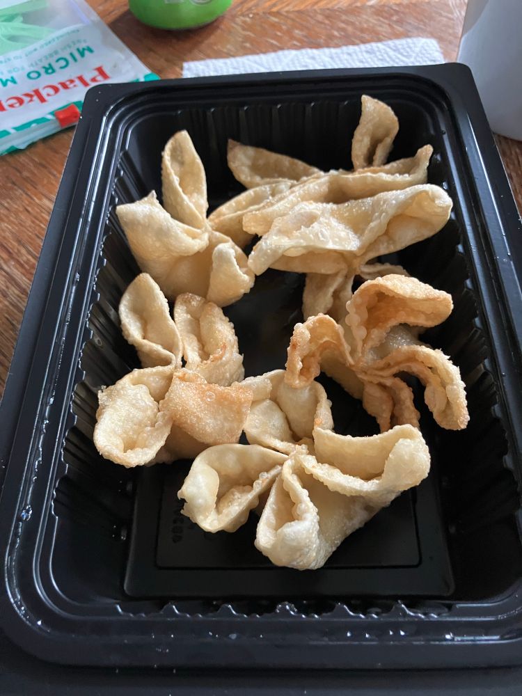 Open takeout tray with 6 crab rangoon inside
