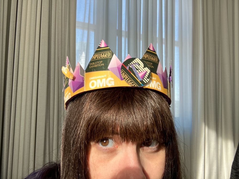 Top of my head with a crown made from PAX omeganaut badges. A submarine and a POG with a T embossed in it are adhered to the crown base.