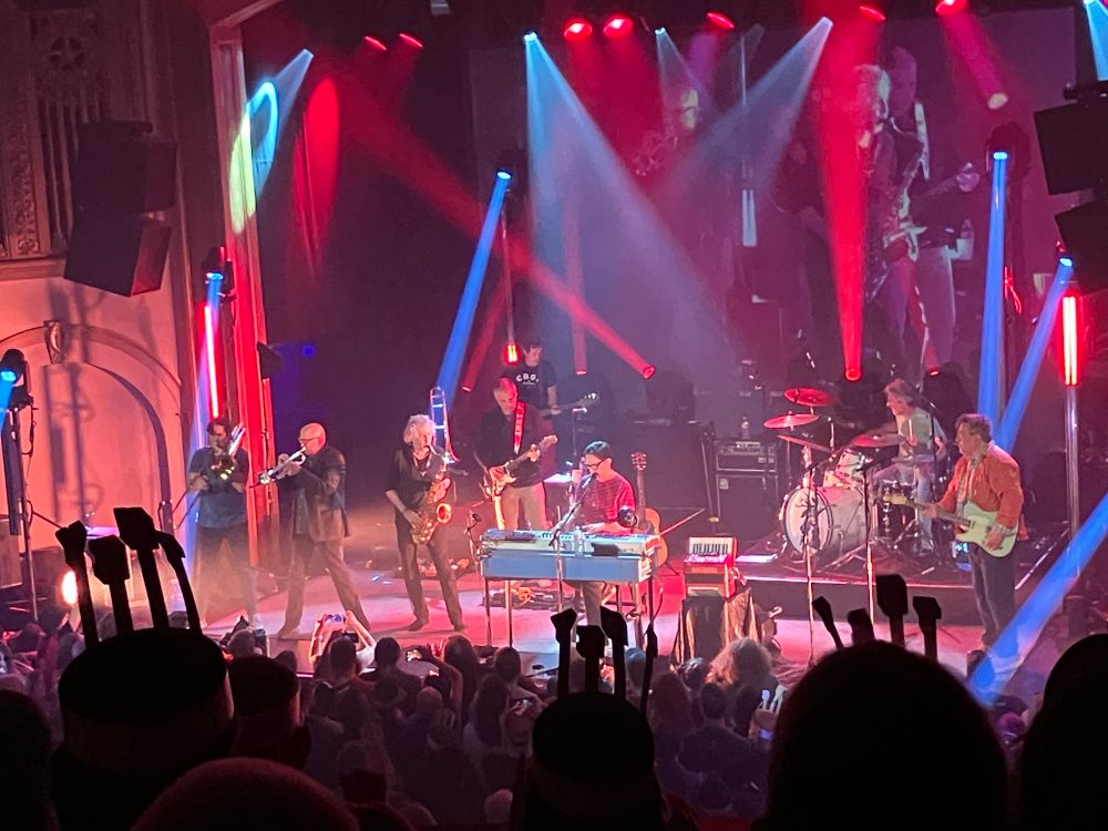 They Might Be Giants +  bonus horn section on a colorfully lit stage. 