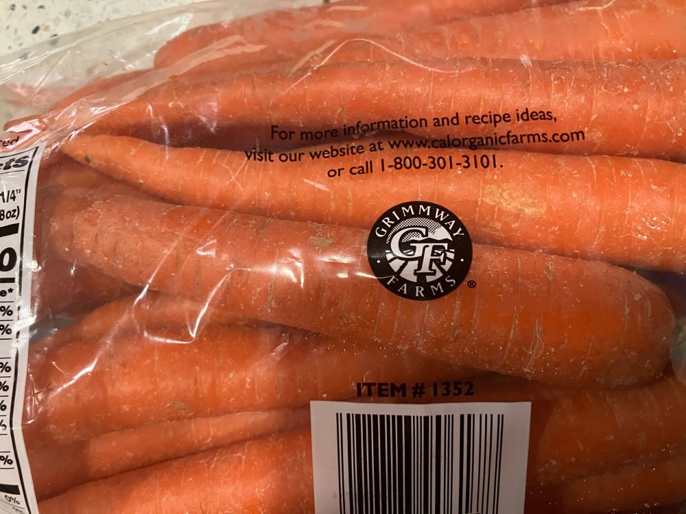 Close up of the back side of a bag of carrots with Grimmway Farms logo centered