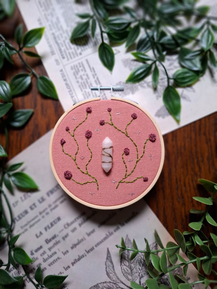 Broderie d'une pierre blanche avec des roses brodées autour