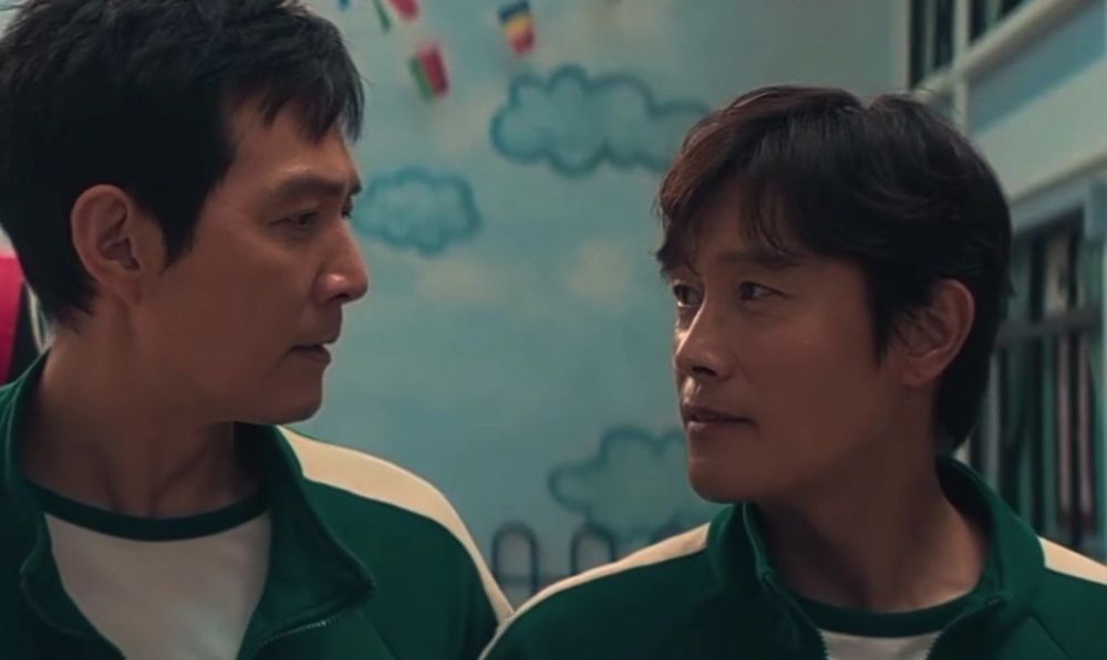 two character from the show squid game. inho is starting at giho with a very intense stare