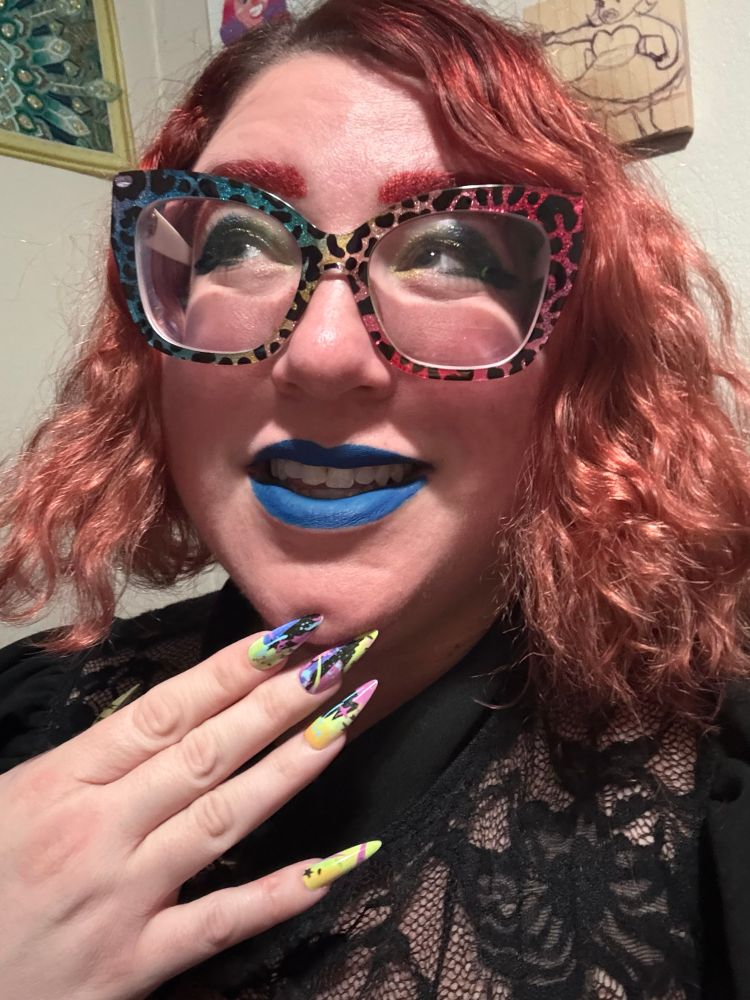 A picture of Stephanie smiling and looking off to the side. Her medium length wavy red hair goes down to her chin.