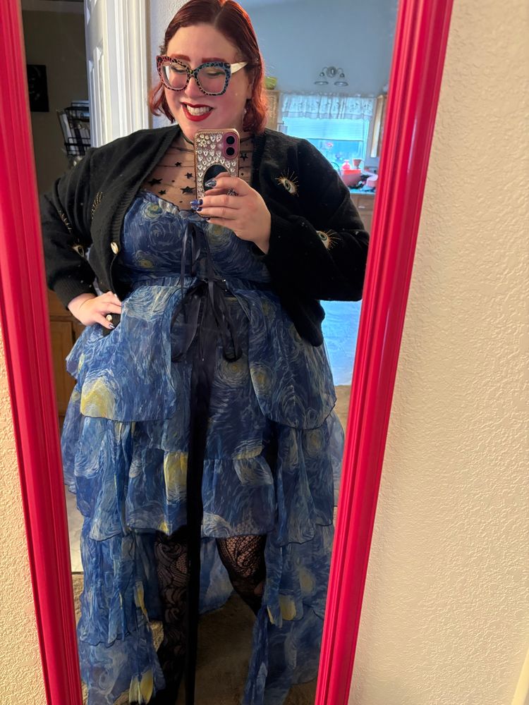 A full body mirror selfie of Stephanie in a high-low floor length tulle dress printed with Van Gogh’s Starry Night