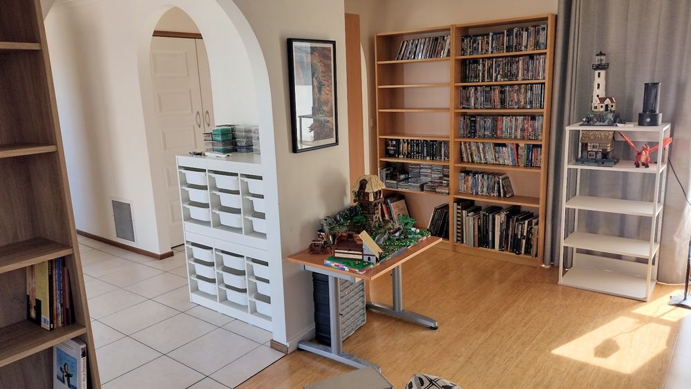 A room full of Billy bookcases is filling up with books and DVDs, and also some Lego sets.