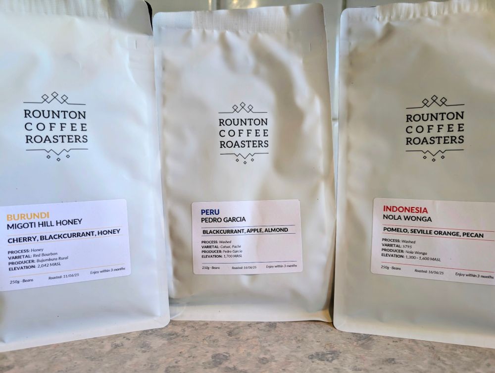 Three bags of coffee beans. Migoti Hill from Burundi, Pedro Garcia from Peru, and Nola Wonga from Indonesia.