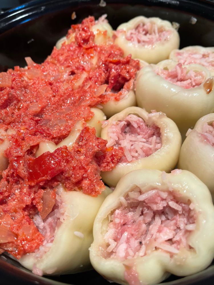Stuffed peppers cooking in a pan