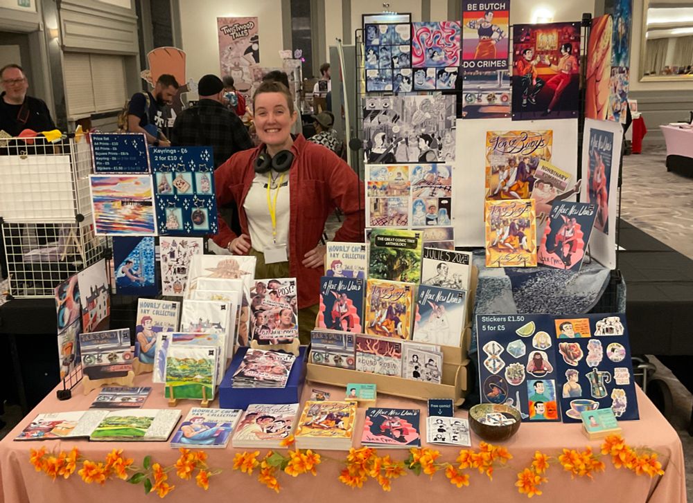 An artist alley display with prints, comics, zines and stickers.