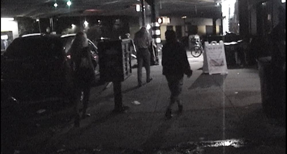 three figures walk down the street