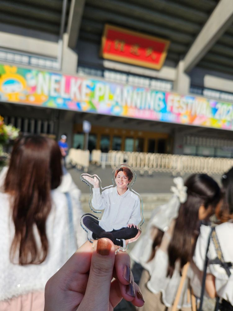 八月。ネルフェス。奥にぼやけた武道館、手前に推しのアクスタと支える私の手。