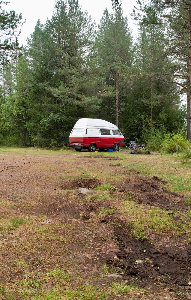 Rot—weißer VW Bulli geparkt am Ende eines Waldwegs in den Schwedischen Fjälls.