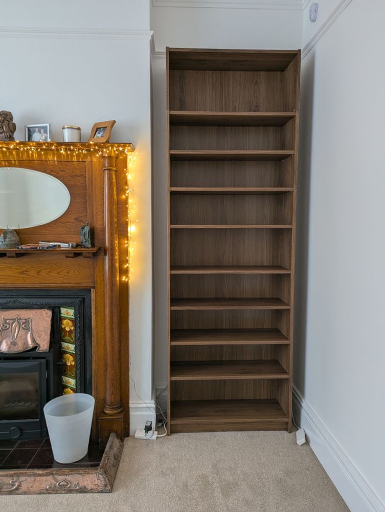 Some ikea Billy shelves next to an old fireplace. No, the colours don't match but they're better than the fake pine ones we had there before. And extra shelves have been placed to maximise space for our extensive movie collection.