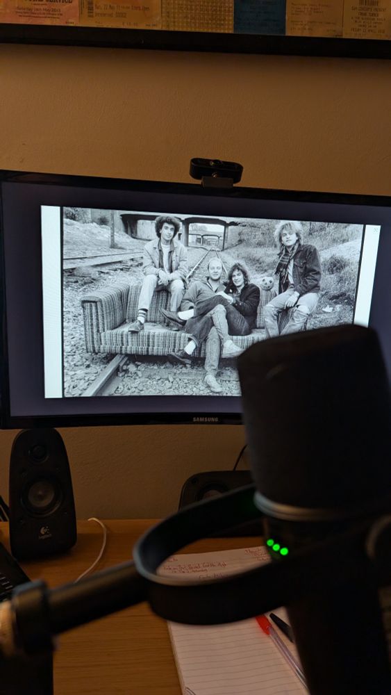 A photo of a mic and of a screen showing The Replacements!
