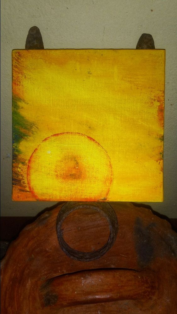 A small painting of a circle not full against a yellow background. It does not look like anything else. On the aides are brushstrokes of different colours. Kinda abstract 