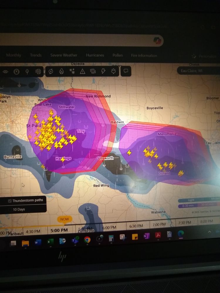 A photo of a laptop screen showing the weather radar. There's two storm areas shown, with a fuck ton of lightning strikes to the right of St. Paul, MN.