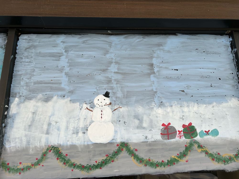 Window painting of a snowman and 4 presents.