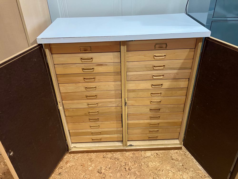 A two door cabinet with door open showing 24 entomology drawers.