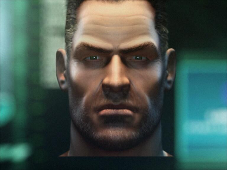 Close-up of Sam Fisher from Splinter Cell: Chaos Theory, showing a stern expression with focused eyes, short dark hair, and a rugged beard, set against a blurred high-tech background. He's locked in.