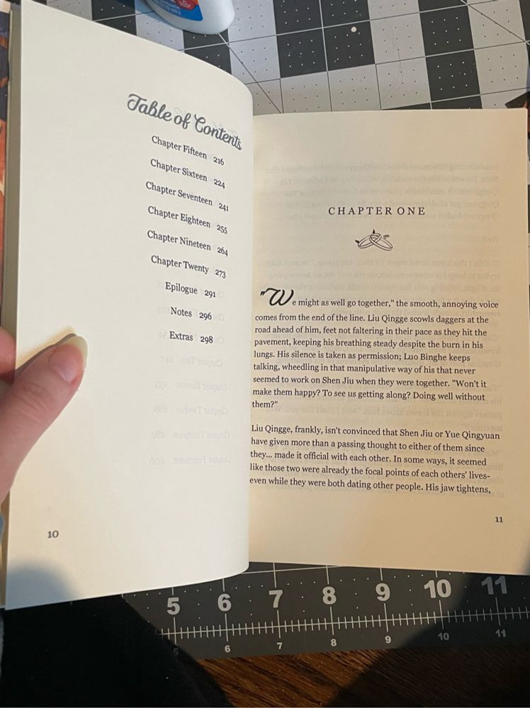 Fourth pic of the come with me fan bind opened to the first chapter page with a small graphic design of two rings interlocked one has devil horns and there is a droplet coming from the other