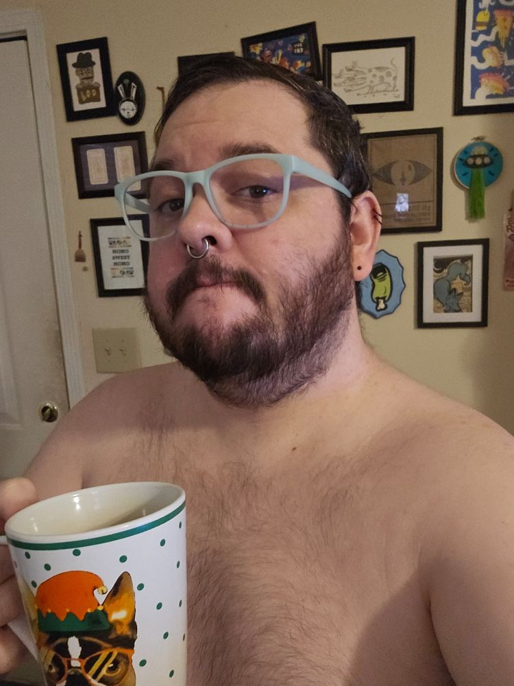 Bearded shirtless person with coffee cup
