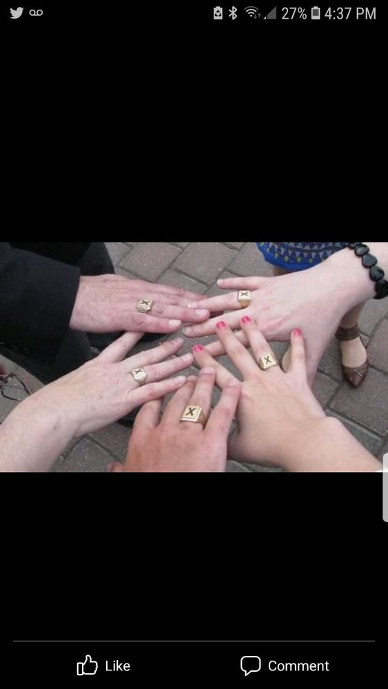 Five hands extended wide in the middle of a circle, showing each hand with the same X-ring.