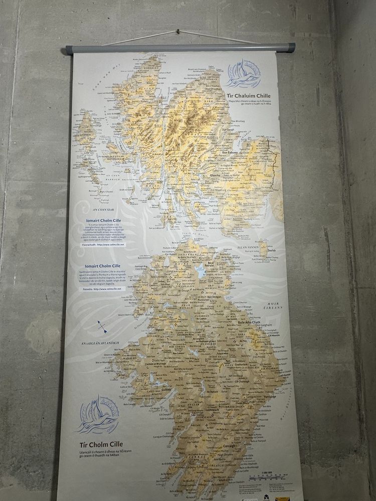 Map of Tír Cholm Cille, celebrating the legacy of St. Colmcille (St. Columba) and the shared Gaelic heritage of Ireland and Scotland. The map features Ireland and Scotland, with place names written in Irish and Scottish Gaelic, highlighting the regions historically associated with the saint and his influence. Key locations include Donegal (Tír Chonaill) in Ireland, closely linked to Colmcille’s birthplace, and the Scottish islands, particularly Iona, where Colmcille founded a renowned monastery. The map showcases the strong linguistic and cultural connections between the two regions, promoting the preservation and celebration of Gaelic traditions. Decorative elements include a logo and title in Gaelic script, with a historical and cultural narrative about Colmcille’s impact. Designed as part of an initiative to honour Gaelic heritage, this map serves as an educational and cultural artifact, emphasising the importance of language, history, and shared identity in the regions of Ireland and Scotland. Perfect for heritage displays, language revival efforts, or educational purposes.