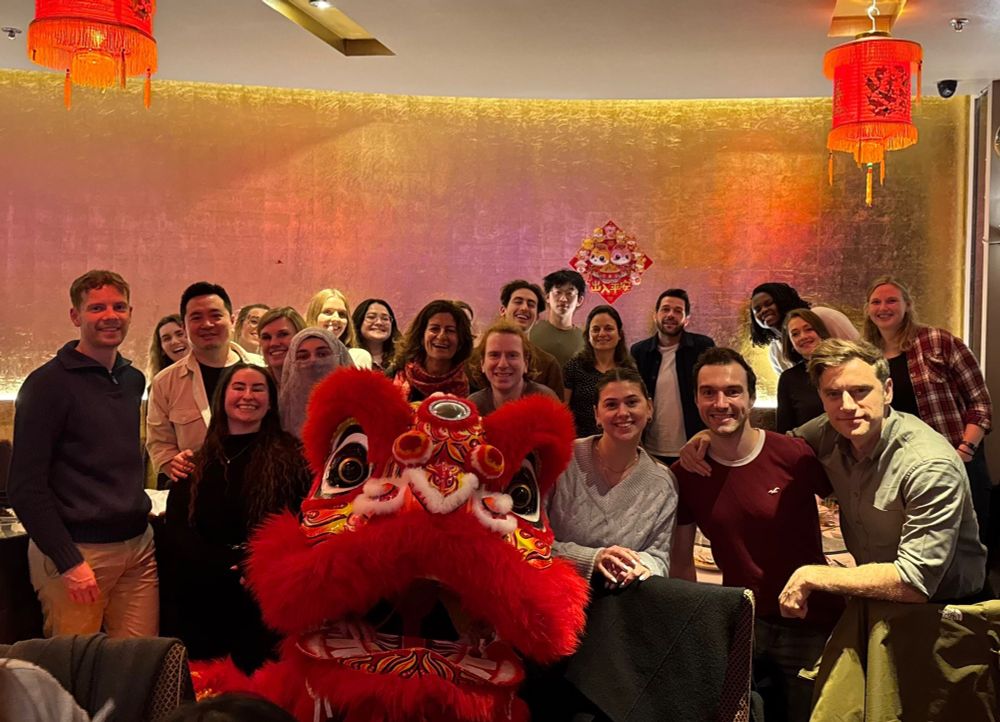 Large group of people celebrating Chinese new year. The photo includes some one dressed in a red traditional Lion Dance costume too. 