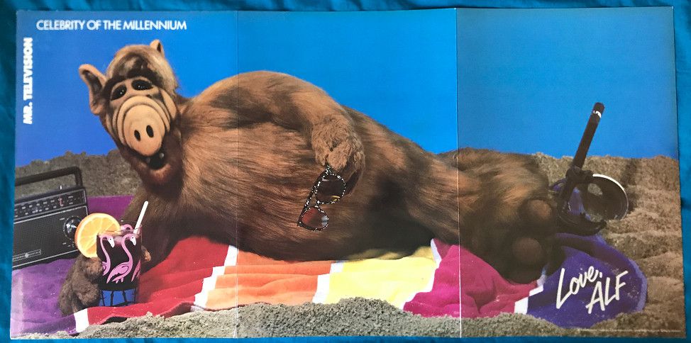Alf, yes the furry alien puppet from the 1980s TV show, laying nude (except for all his fur, of course) on a beach blanket in a pose reminiscent of centerfold beefcake pictures from the likes of Playgirl Magazine. 