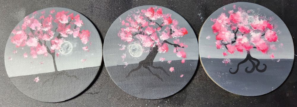 3 circle magnets with pink sakura trees painted on with Grey background 