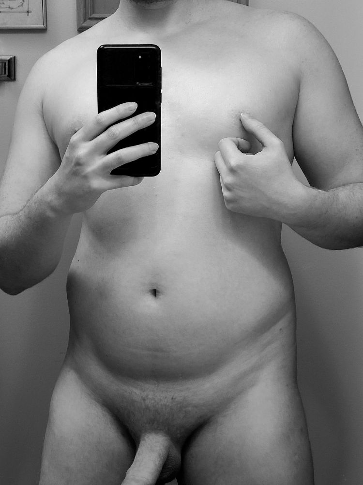 a mirror pic of my naked playing with my nipple and part of my cock in frame 