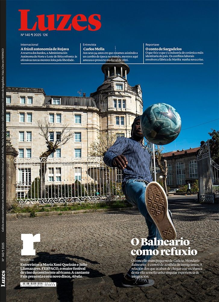 Capa da revista Luzes na que se pode ver o balneario de Mondariz e diante, en primeiro plano, un rapaz inmigrante dando toques cun balón de fútbol.
Debaixo, o título da reportaxe: O Balneario como refuxio.
O concello máis pequeno de Galicia, Mondariz Balneario, é centro de acollida de inmigrantes. A relación dos que acaban de chegar coa veciñanza desta vila semella unha singular experiencia de integración.