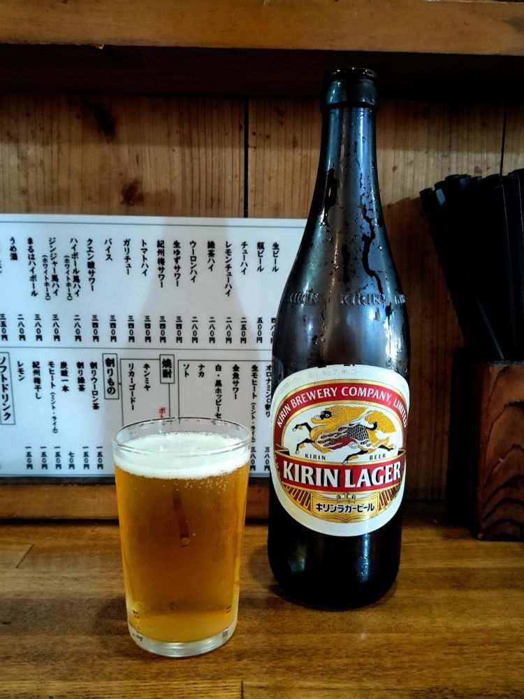 大衆的な居酒屋のカウンター席に置かれた瓶ビール