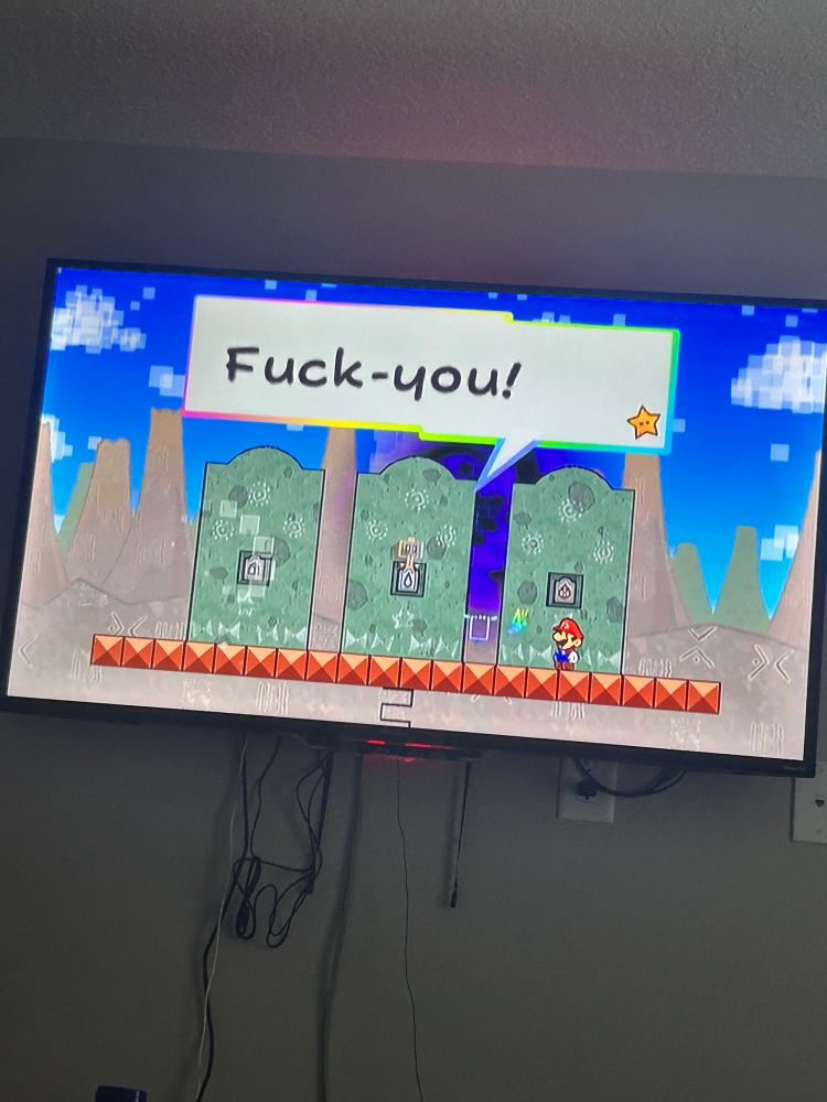 an image of me playing super paper mario on my tv; in it, cudge, the pixl, is shouting “fuck-you!”