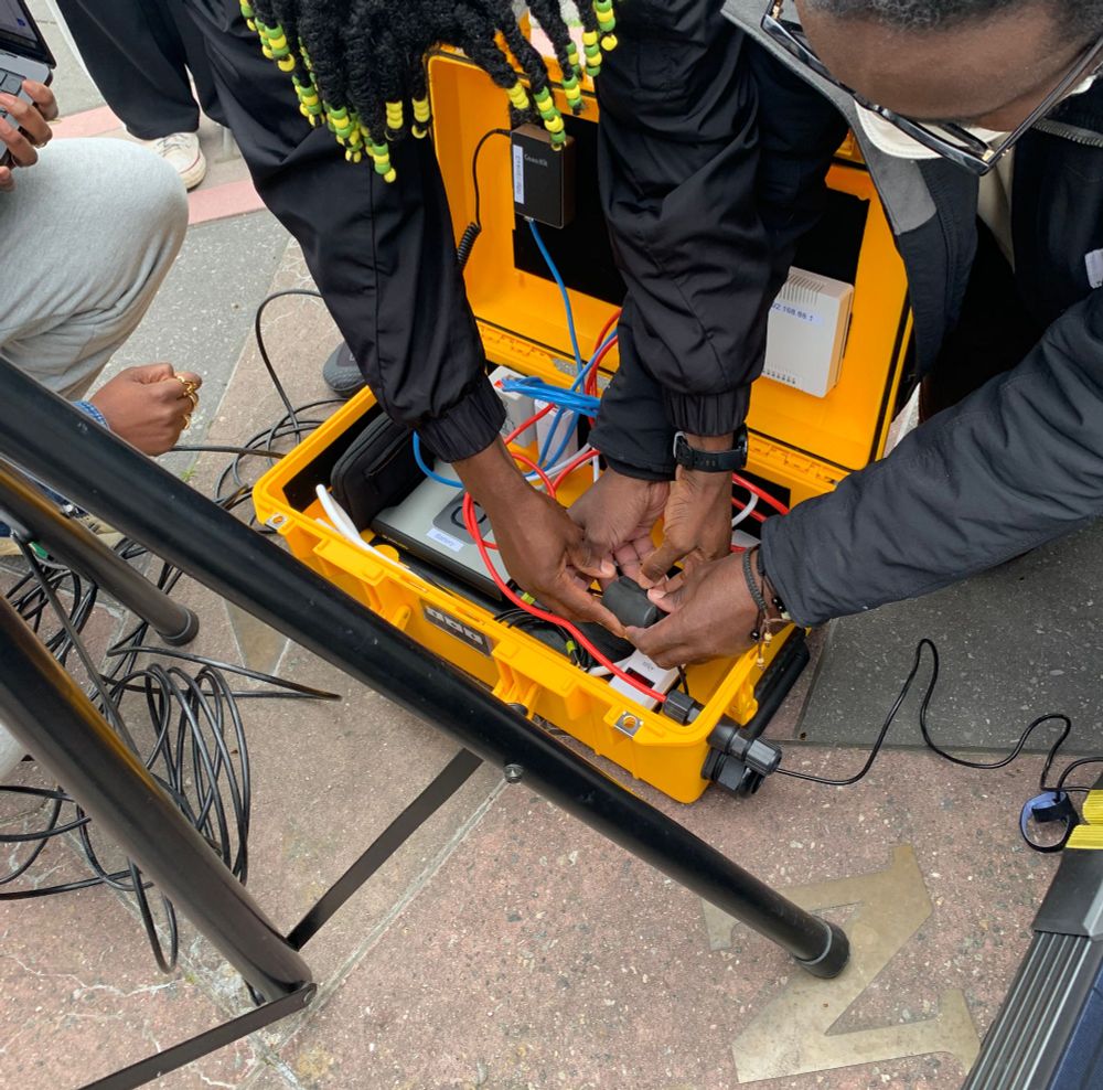 New digital stewards setting up the PNK - contained in a bright yellow Pelican case - outside at the Continental Army Plaza in Wiliamsburg Brooklyn for El Puente's climate justice event