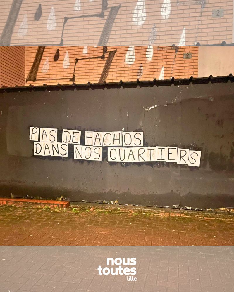 Collage sur un mur gris foncé « PAS DE FACHOS DANS NOS QUARTIERS »