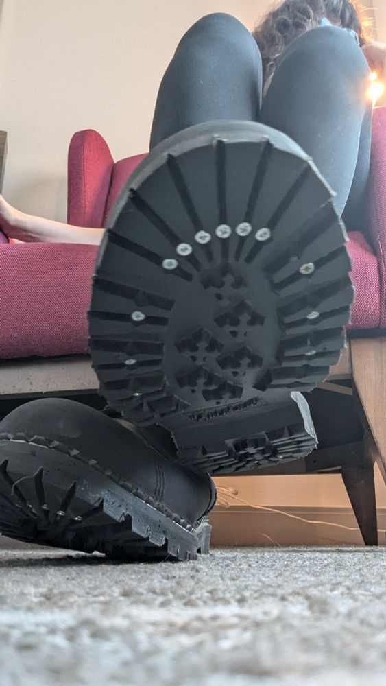 boots with screws in the bottoms from a low angle perspective