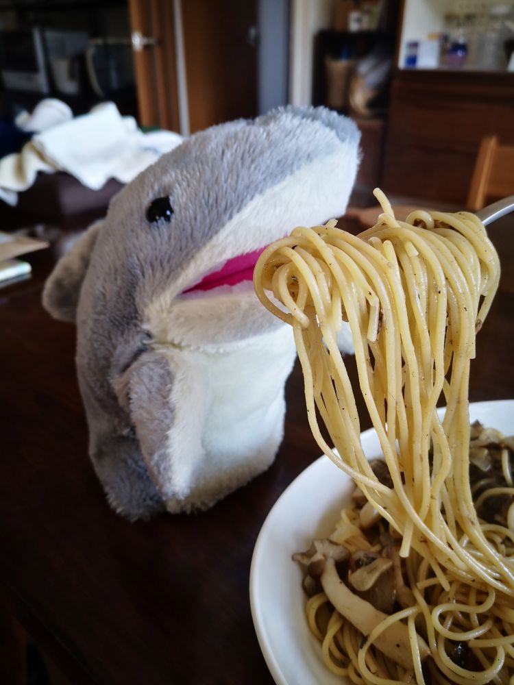 サメのぬいぐるみにスパゲッティを食べさせている
