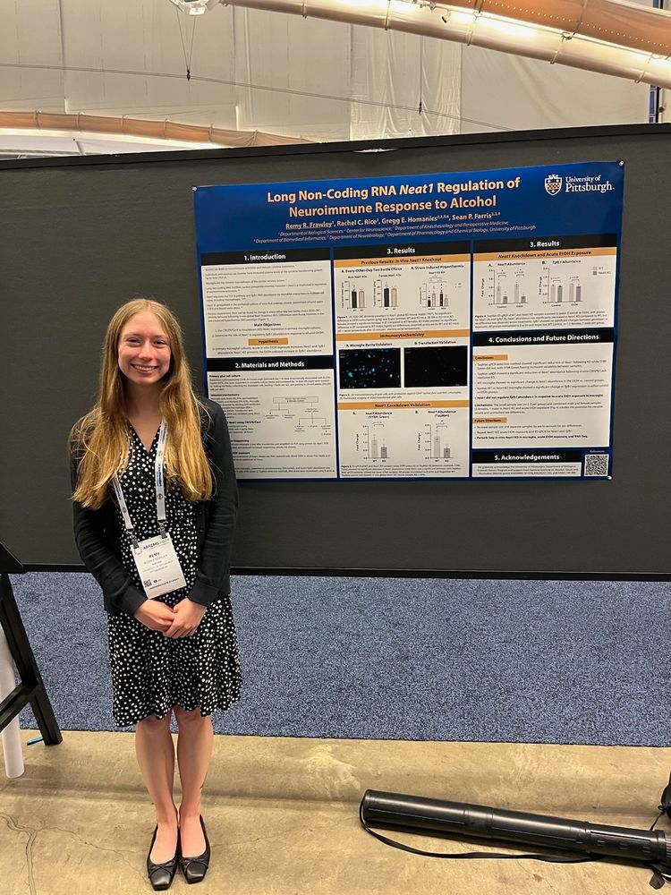 A smiling undergraduate student in professional clothing poses next to her poster she is presenting at her first scientific conference. 