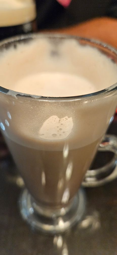 A photo of a hot chocolate in a glass.