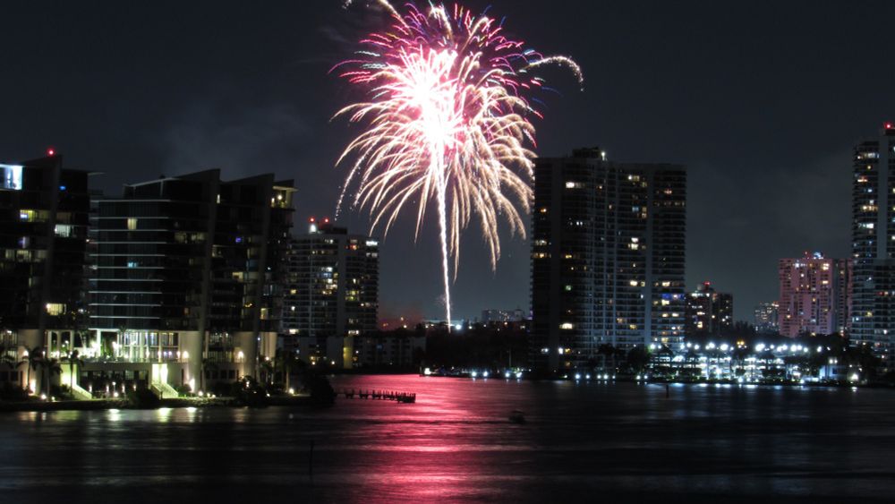 Aventura's Fourth of July fireworks show reflecting on Dumfoundling Bay as seen from Sunny Isles Beach, Florida.