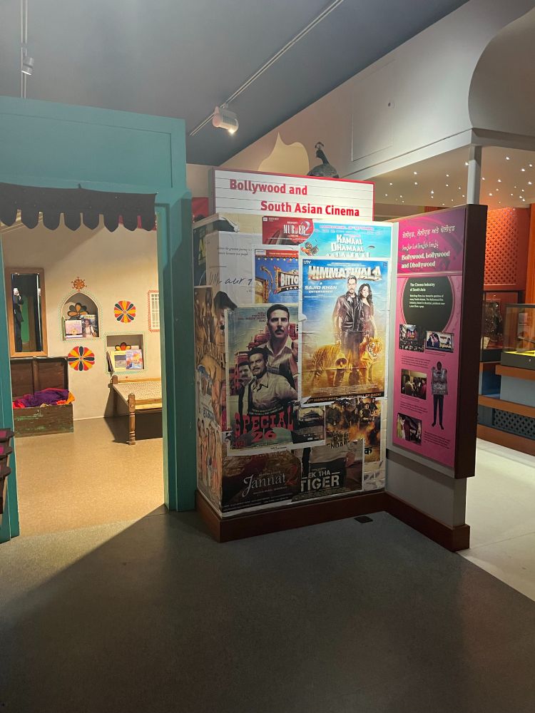 Image of a museum exhibition showing film posters from Bollywood and South Asian cinema