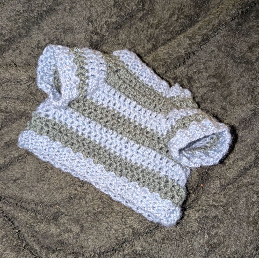 une photo du pull posé sur un plaid, avec le flash