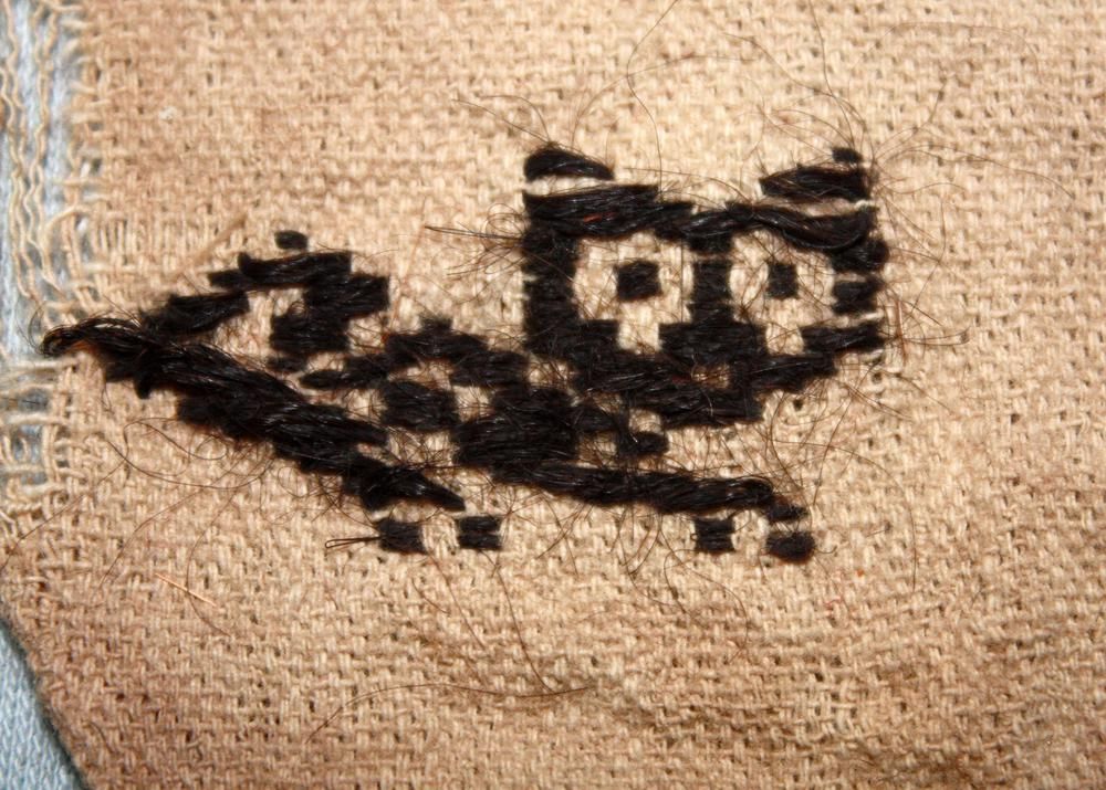 Plano detalle del gatito que parece hecho de pixeles, con unos ojos enormes y redondos. Se ve textura como de pelo, en la web pone que es pelo de camélido (¿Llama o alpaca seguramente?)