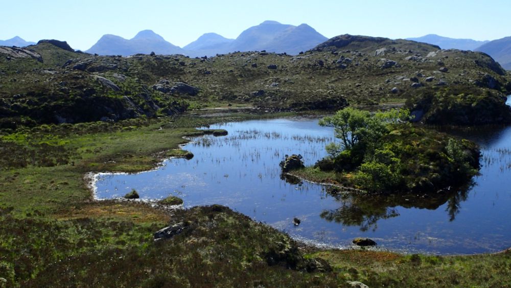 Lochan in Torridon with island that has trees and higher vegetation