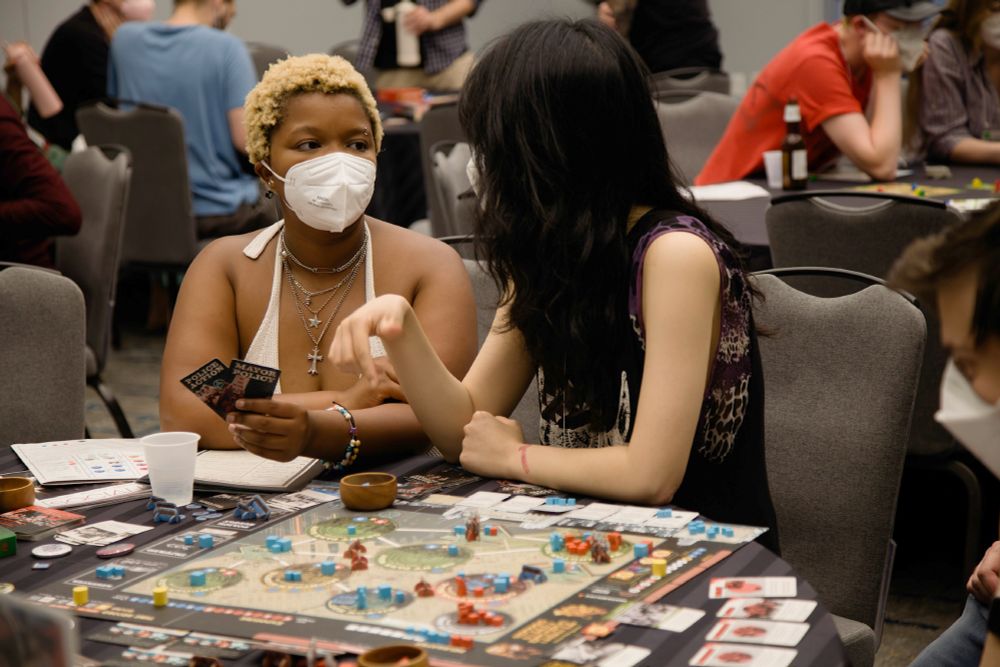 Two players holding cards and considering their next move in Chicago '68